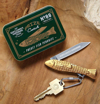 the pocket fish knife displayed on a wood surface with the metal tin case
