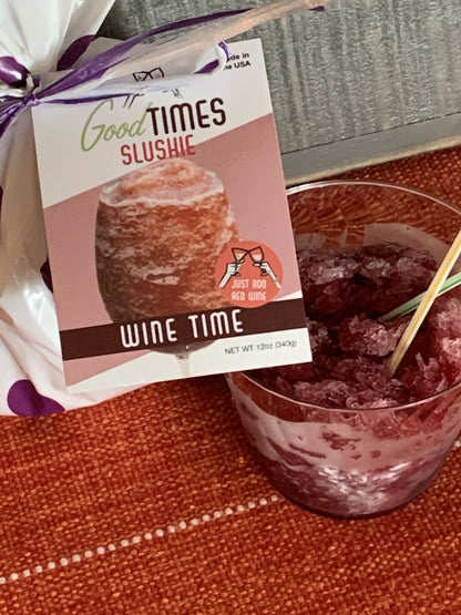 wine time slushie in a glass next to the package on a rust colored tablecloth