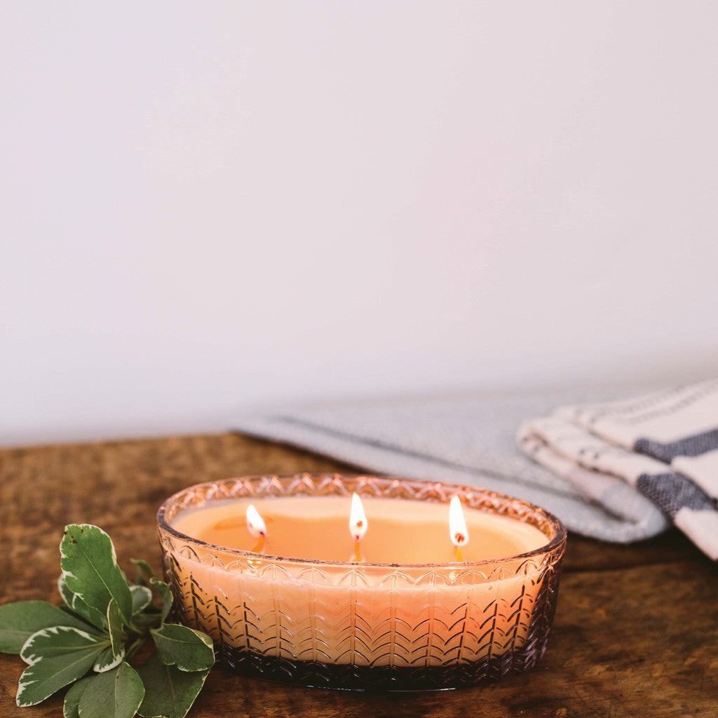 sweet grace candle on a rustic wood table against a white background