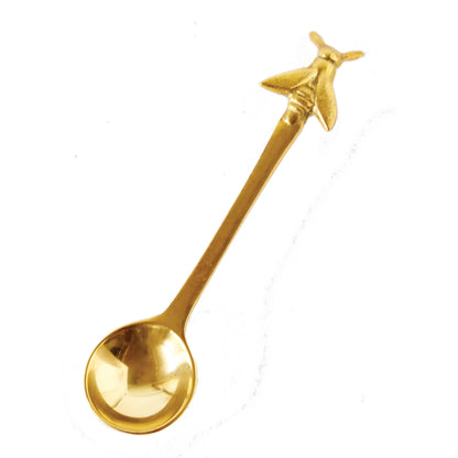 brass spoon with bee on a white background