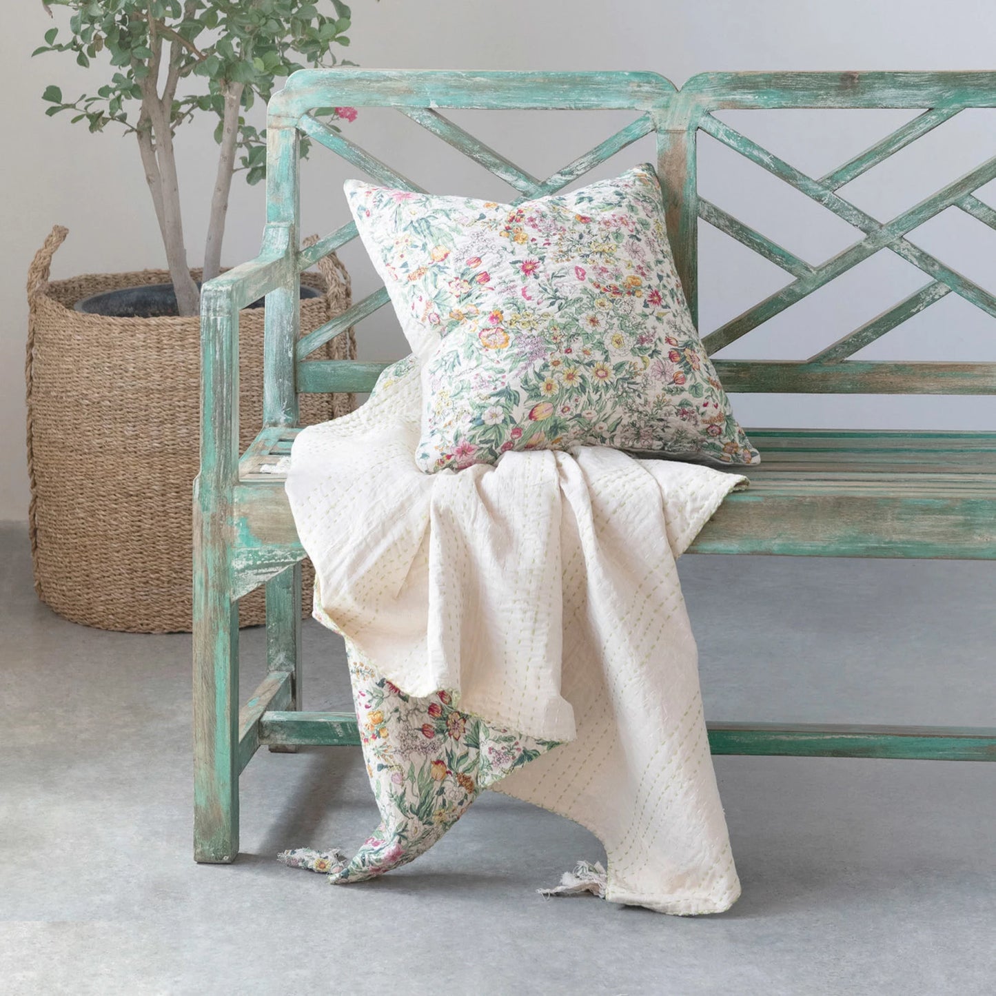 pillow on a bench with a blanket.