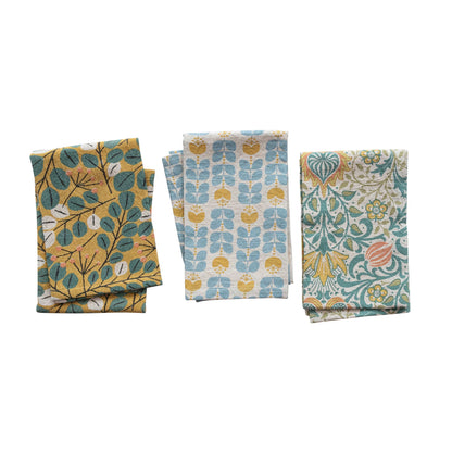 all three styles of botanical pattern tea towel folded and displayed against a white background