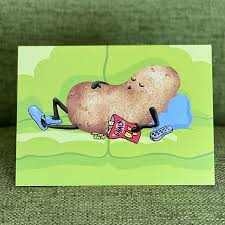 the front of card has a potato dressed like a human resting on a couch