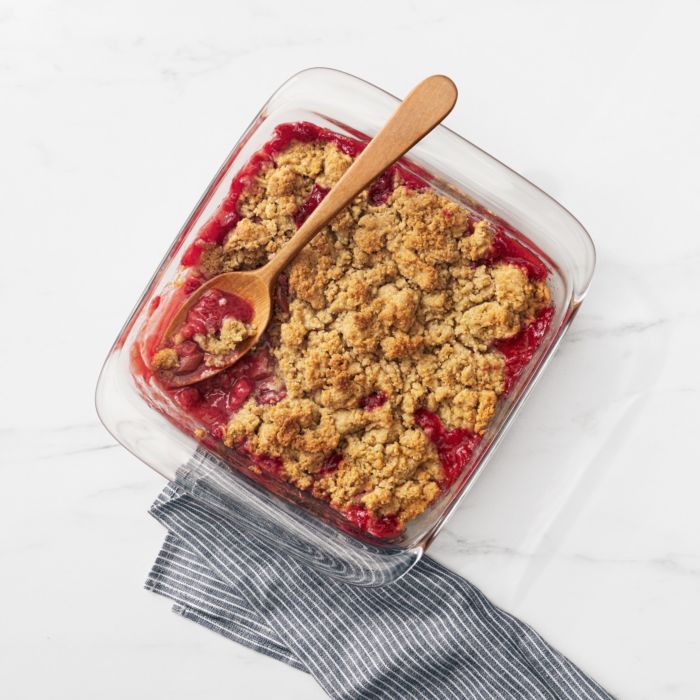 top view of baking dish filled with cherry cobbler and a wooden spoon.
