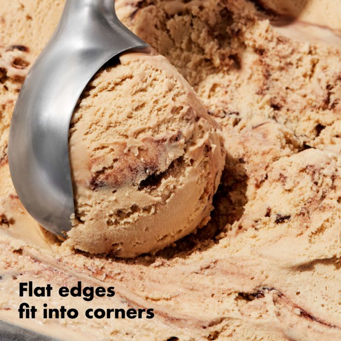 close-up of scoop scooping chocolate ice cream with text "flat edges fit into corners".