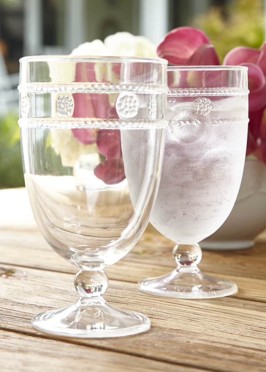 two isabella acrylic goblets displayed on a wood table with a floral arrangement