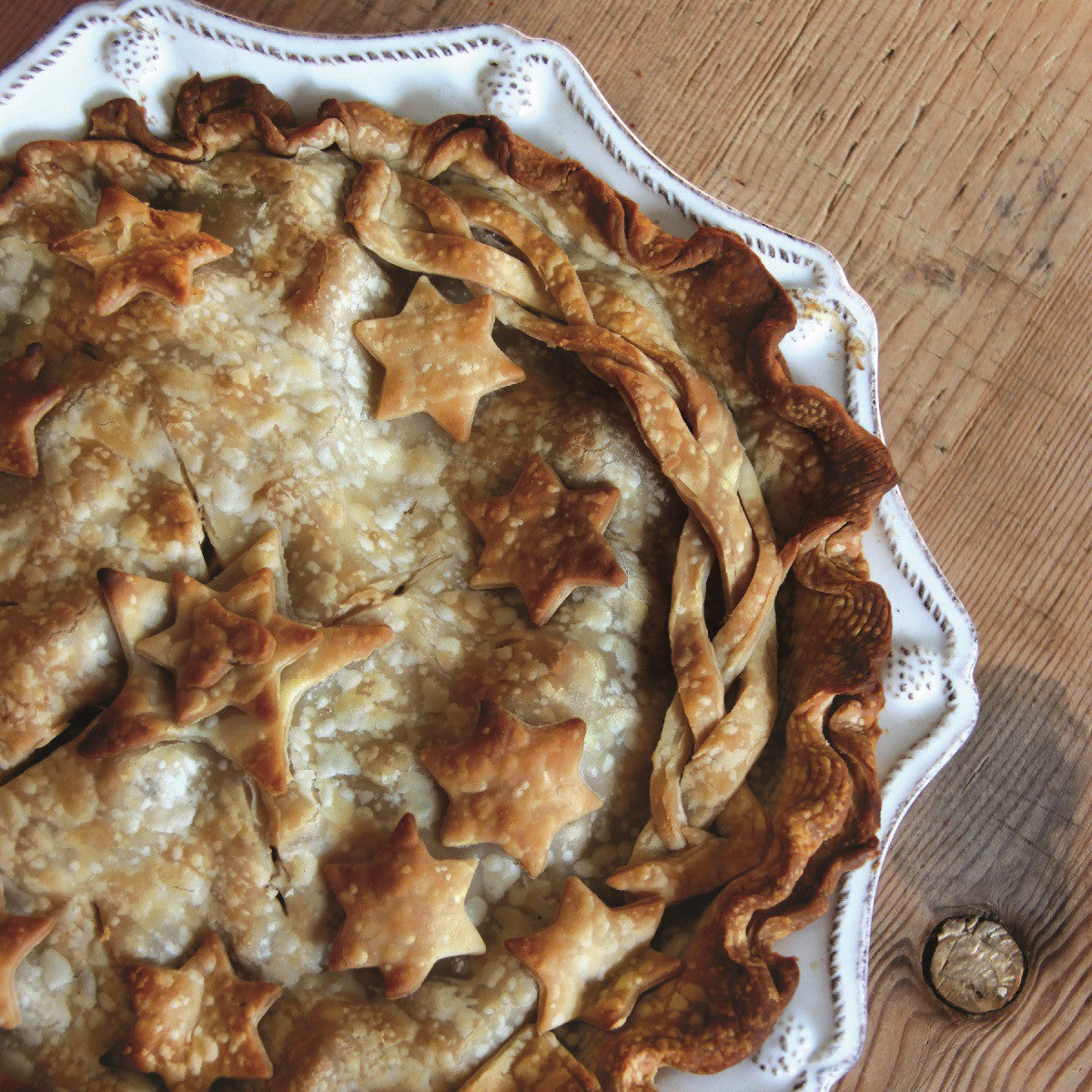 display of the berry and thread pie quiche dish filled with a baked pie on a wood table