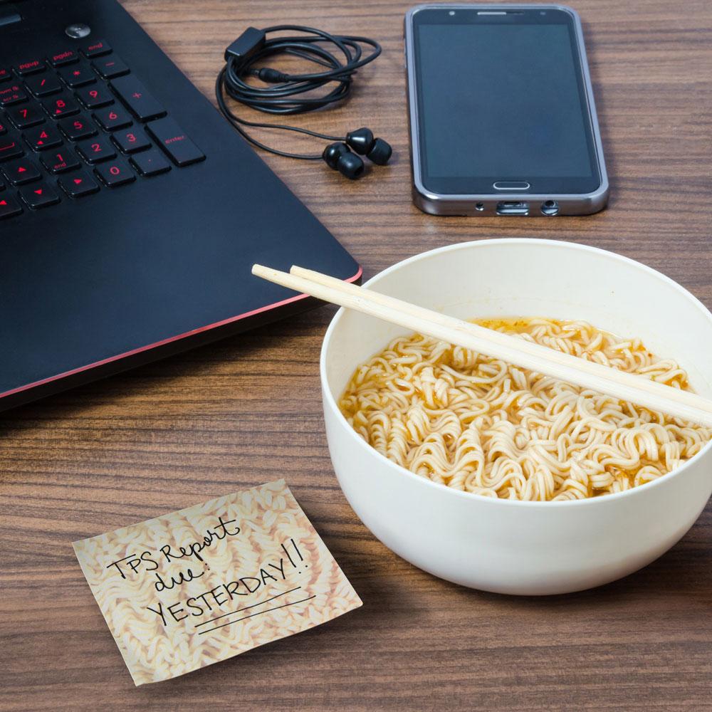 the ramen sticky notes sitting on a table beside a bowl of ramen and computer and cell phone