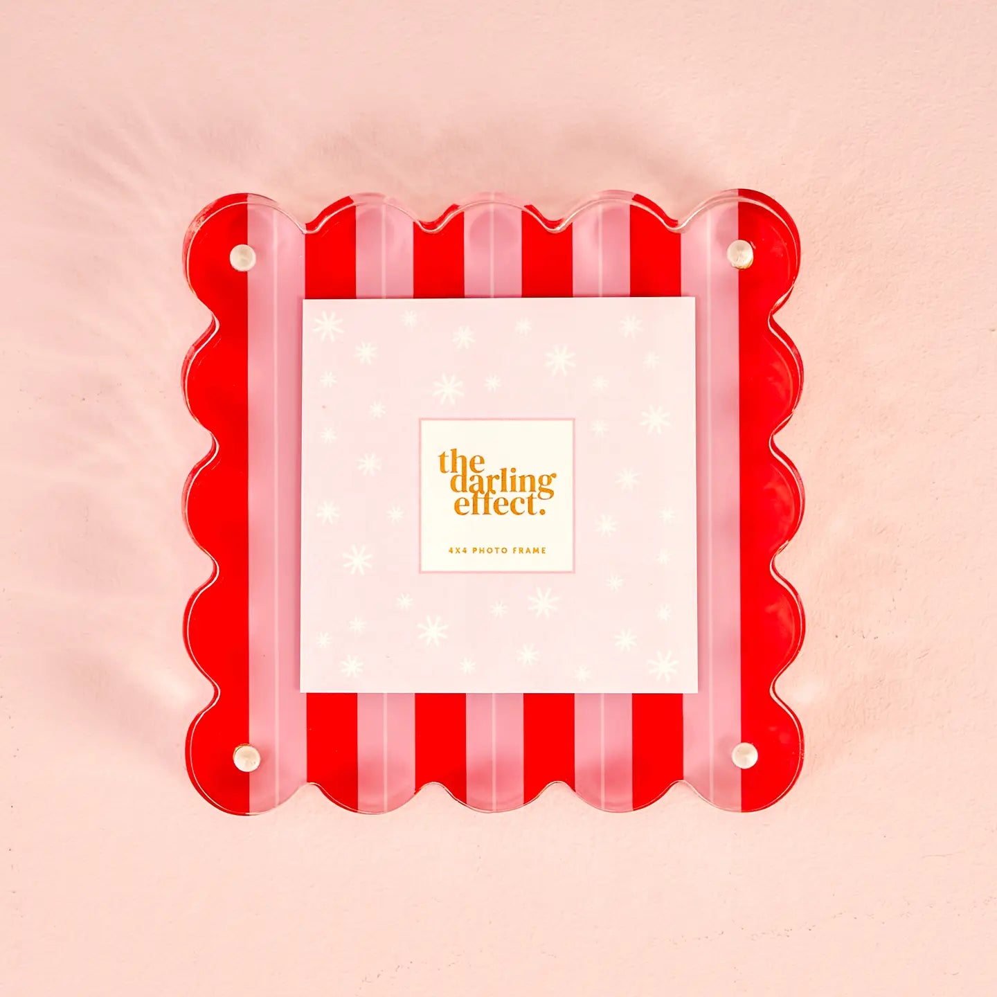 Red and pink striped acrylic photo frame on a pink background