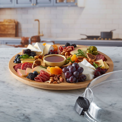 Round Build a board filled with fruit, meats and cheese set on a counter with the lid next to it.
