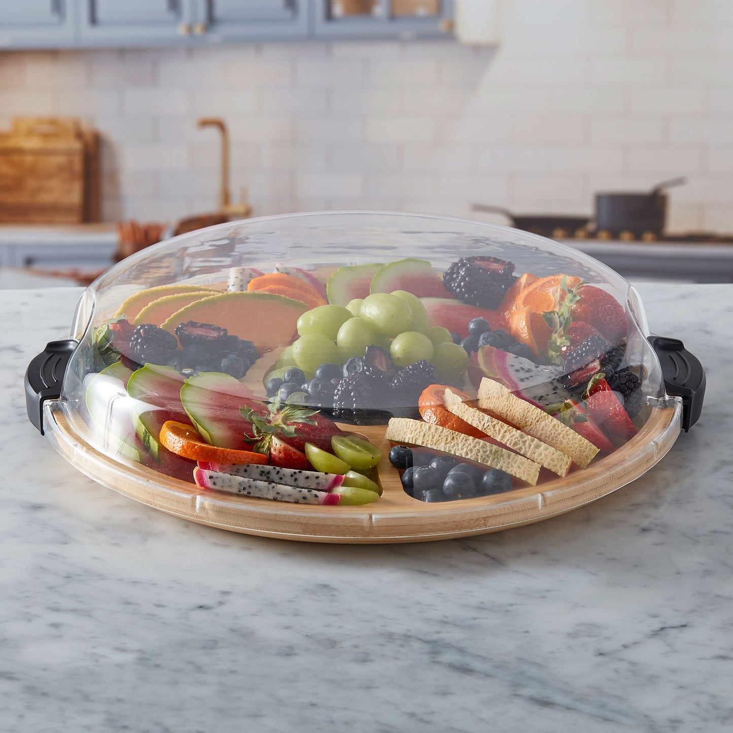 Round builder board filled with fruits with the lid on it.