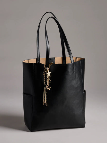 black Starlet Bag Charm hung on a black tote