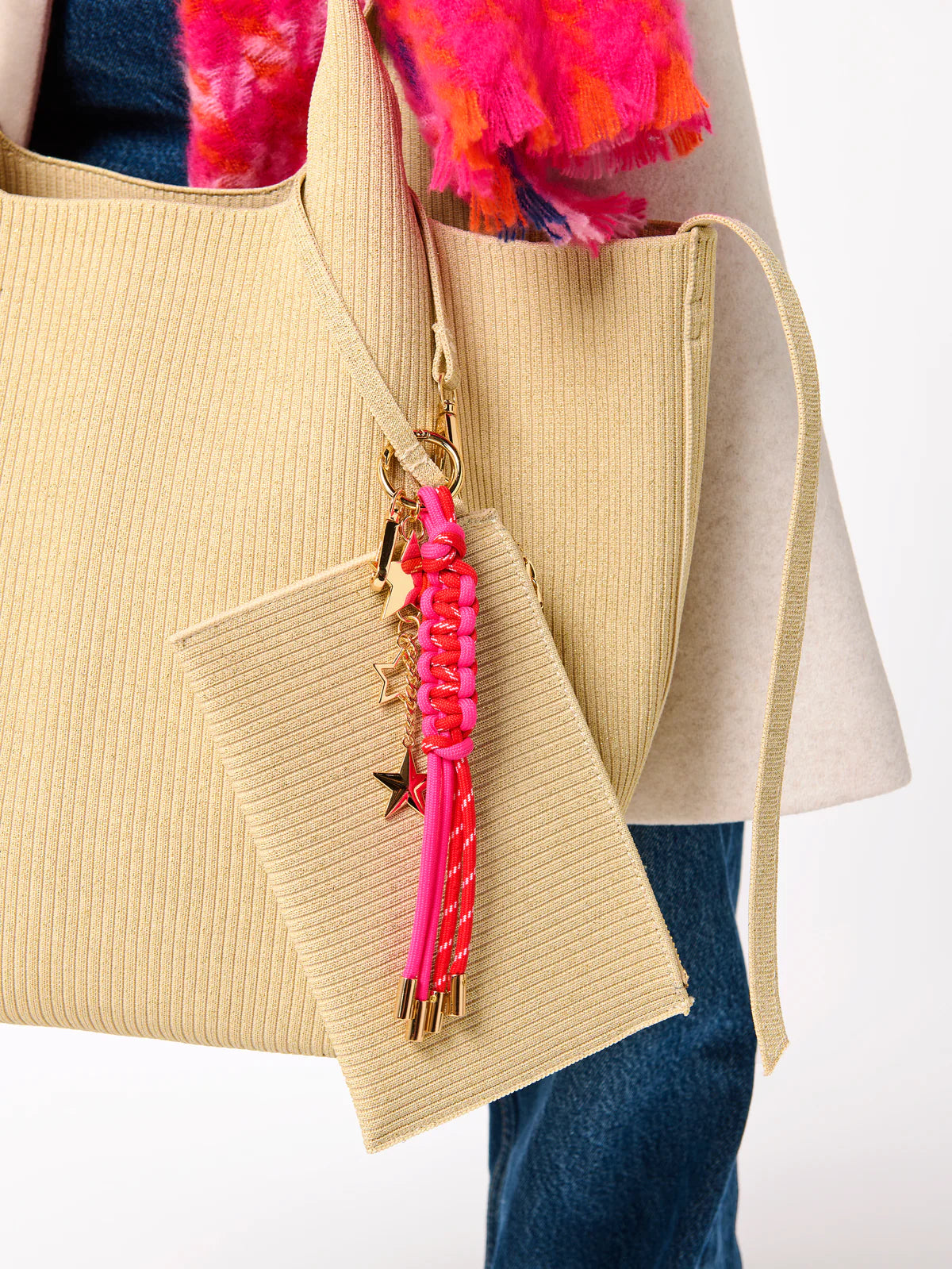 close-up of pink Starlet Bag Charm hung on a beige tote