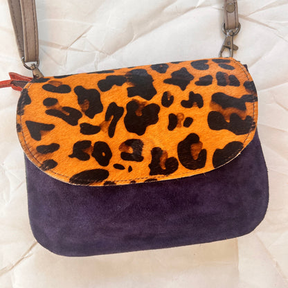 leo purse with navy body and cheetah print flap.