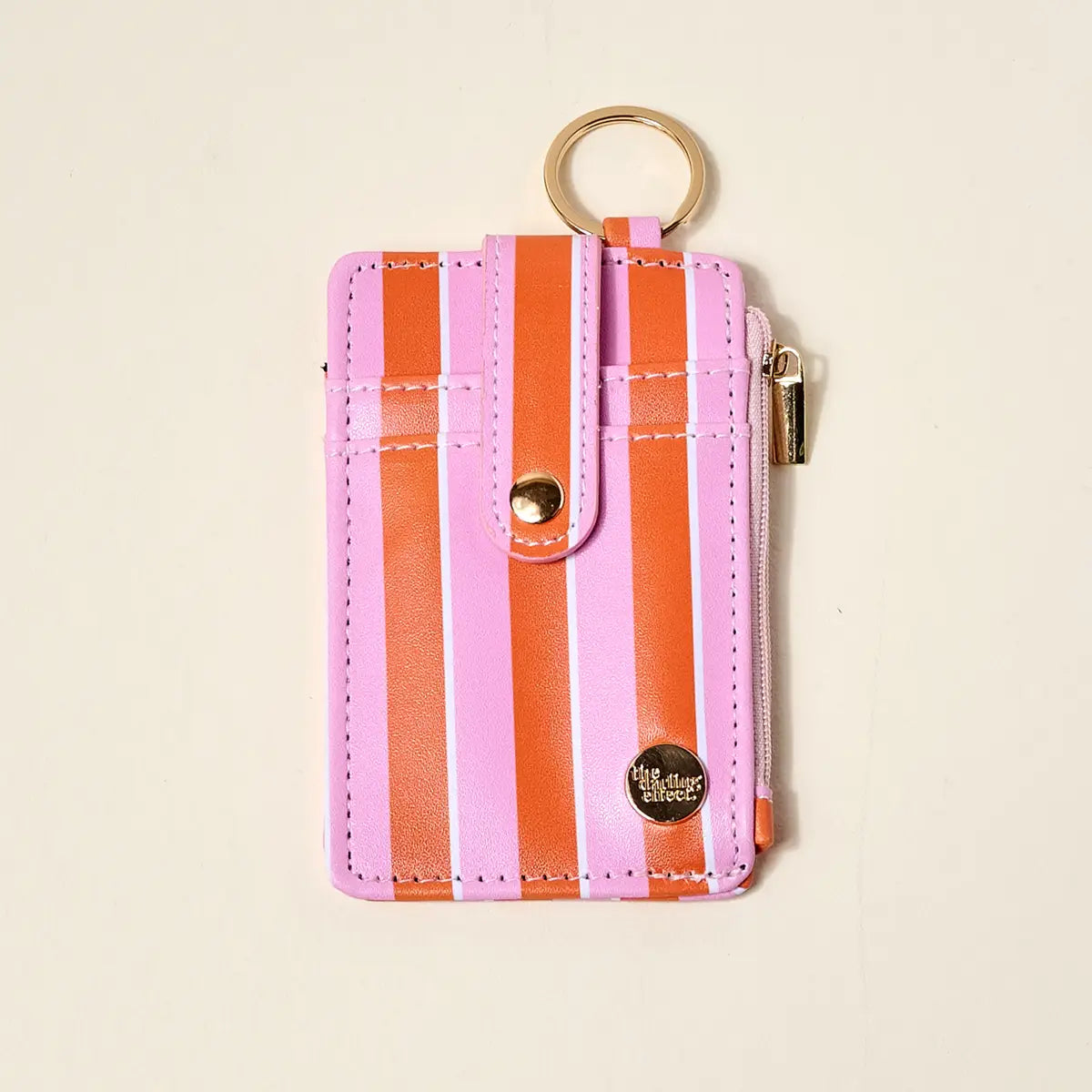Pink and orange striped keychain wallet on a beige background