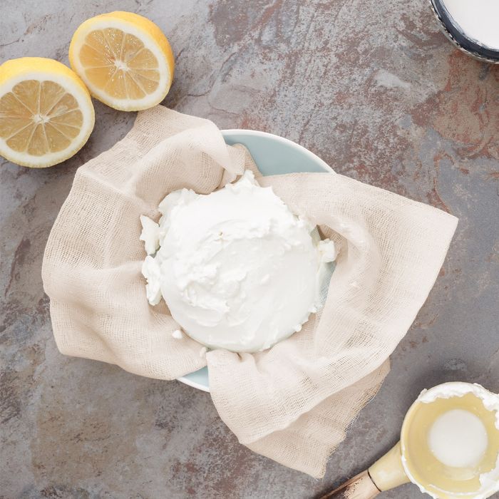 cheese cloth lining a bowl filled with soft cheese