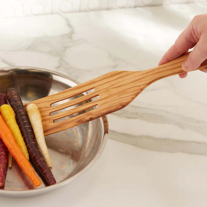 hand using Olive Wood Slotted Spurtle to move veggies in a pan