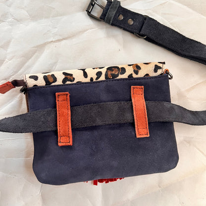 solid blue back of bag with orange loops holding a grey belt.