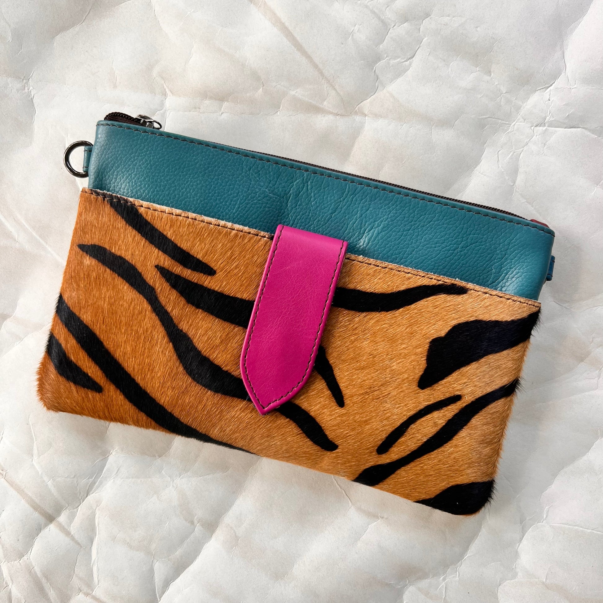 turquoise rectangular bag with animal print hair-on-hide pocket, and fuchsia tab.