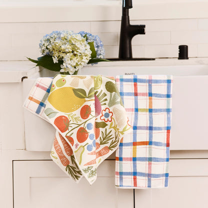 Two farm stand dish towels draped over A drawer at the kitchen sink.