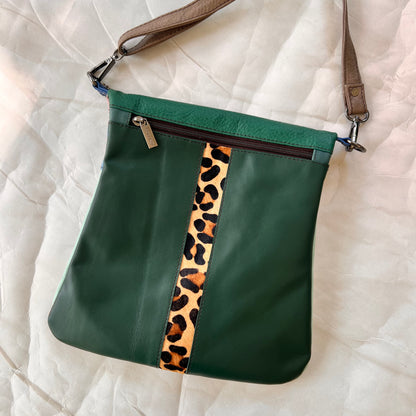 green greta bag with animal print stripe down the center and zipper at the top.