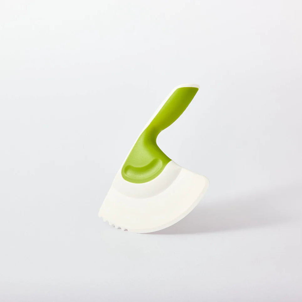White and green kitchen chopping tool on a light gray background