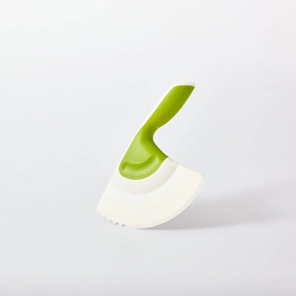 White and green kitchen chopping tool on a light gray background