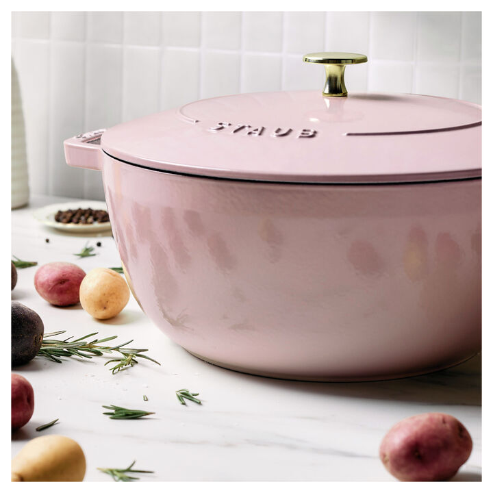 Sorbet rose French oven set on a kitchen counter surrounded by herbs