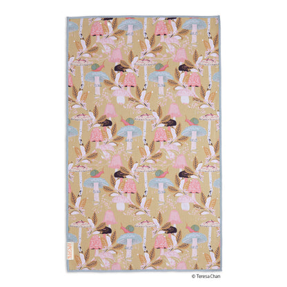 beige towel with mushroom and foliage design laying on a white background