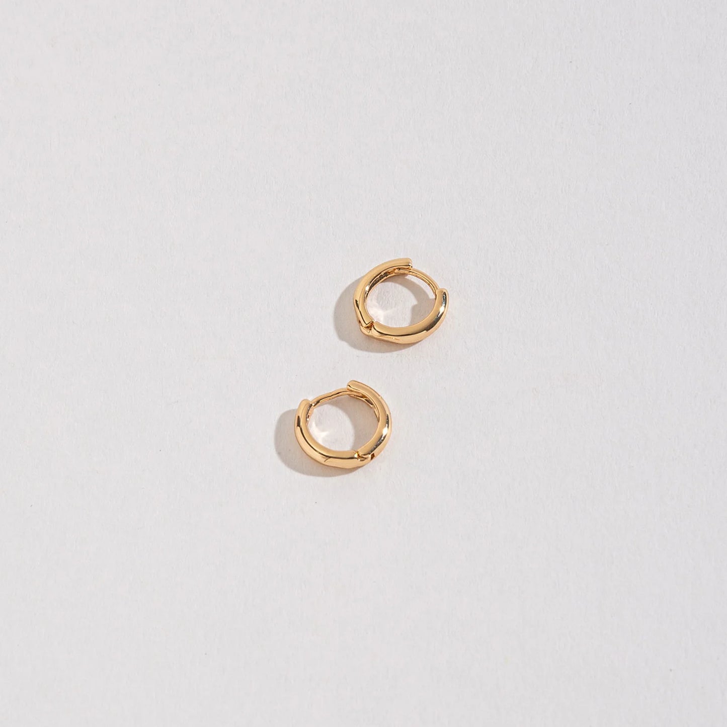 Small Huggie Hoops on a white background.