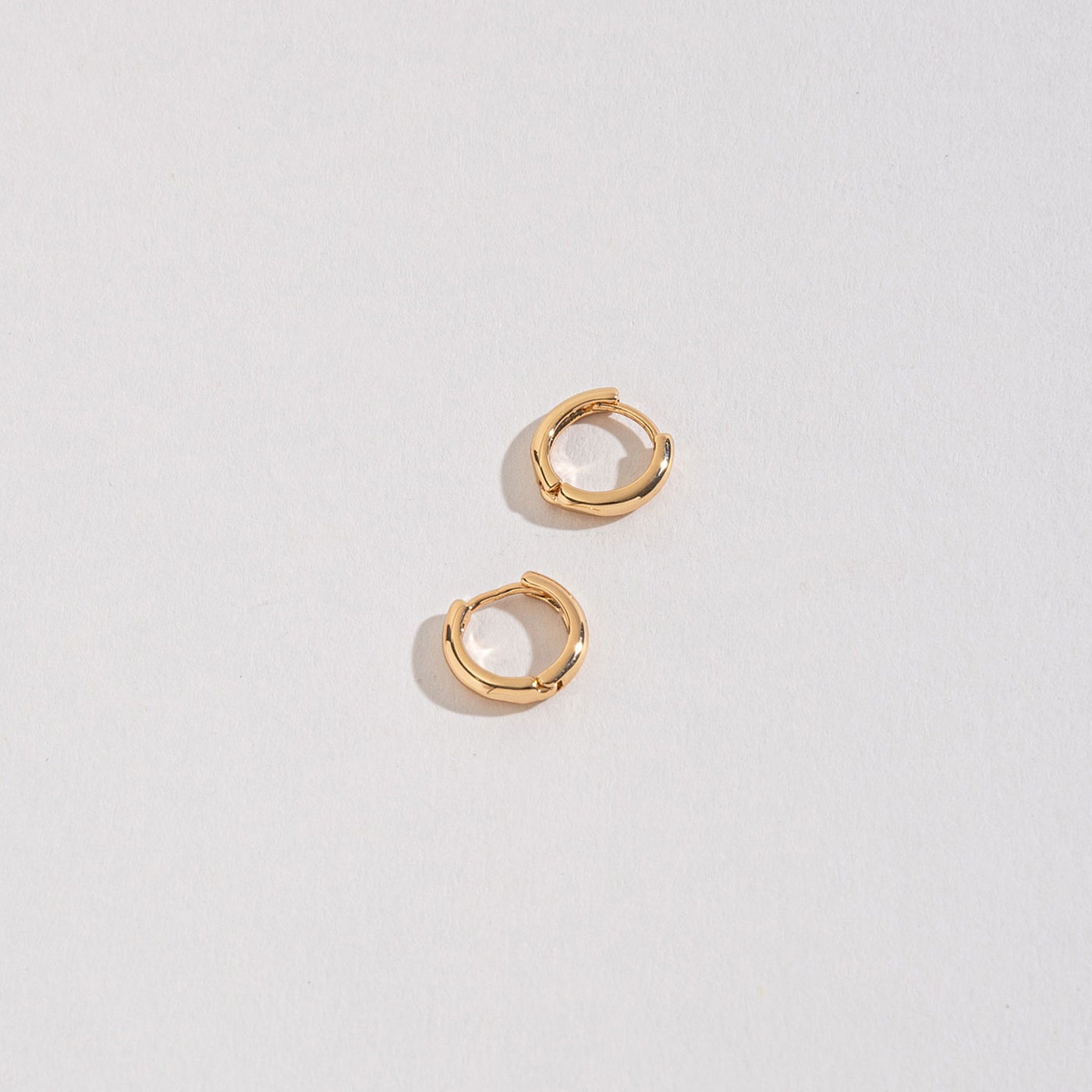 gold huggie hoops on a white background.