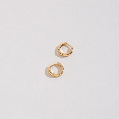 gold huggie hoops on a white background.