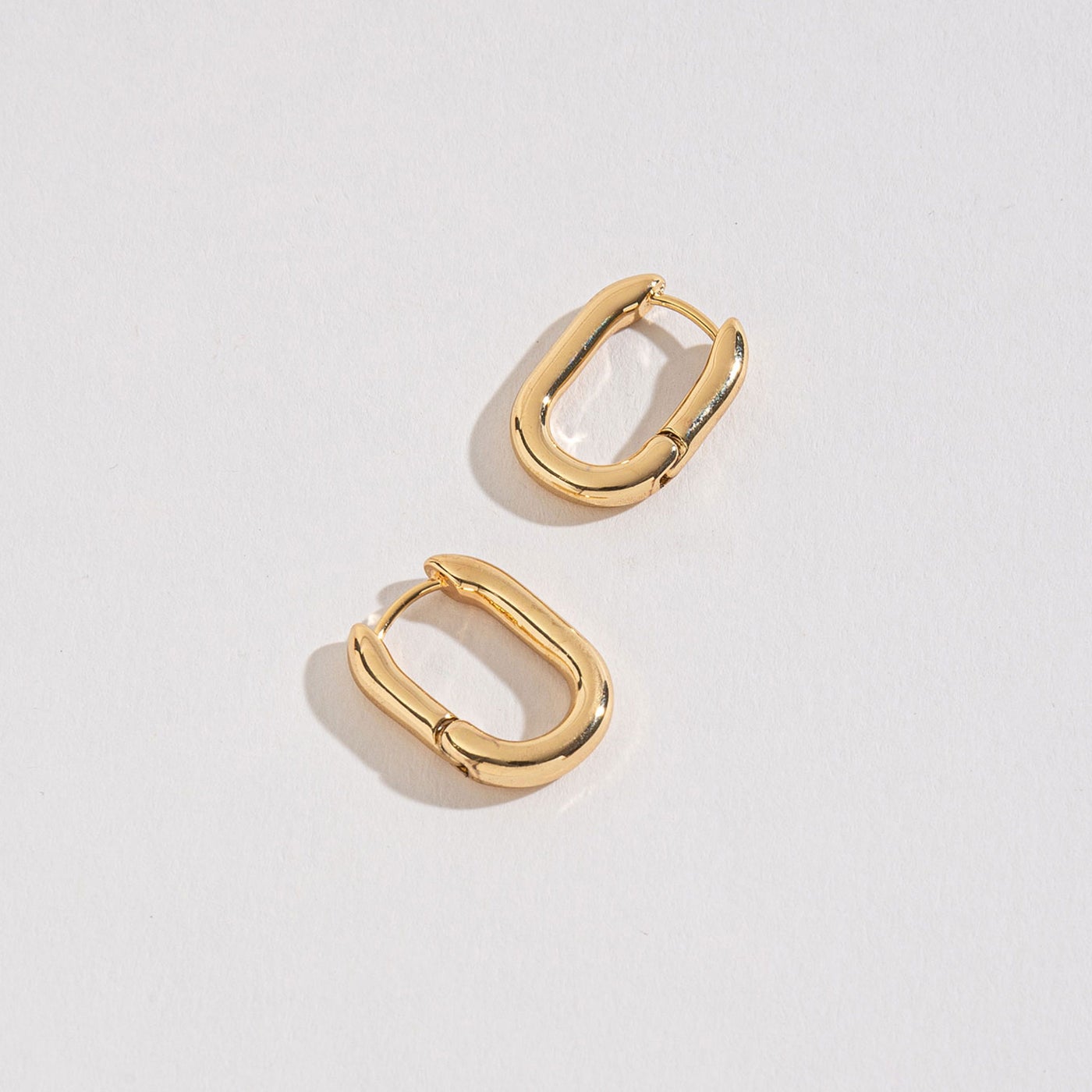 gold medium link huggie hoops on a white background.
