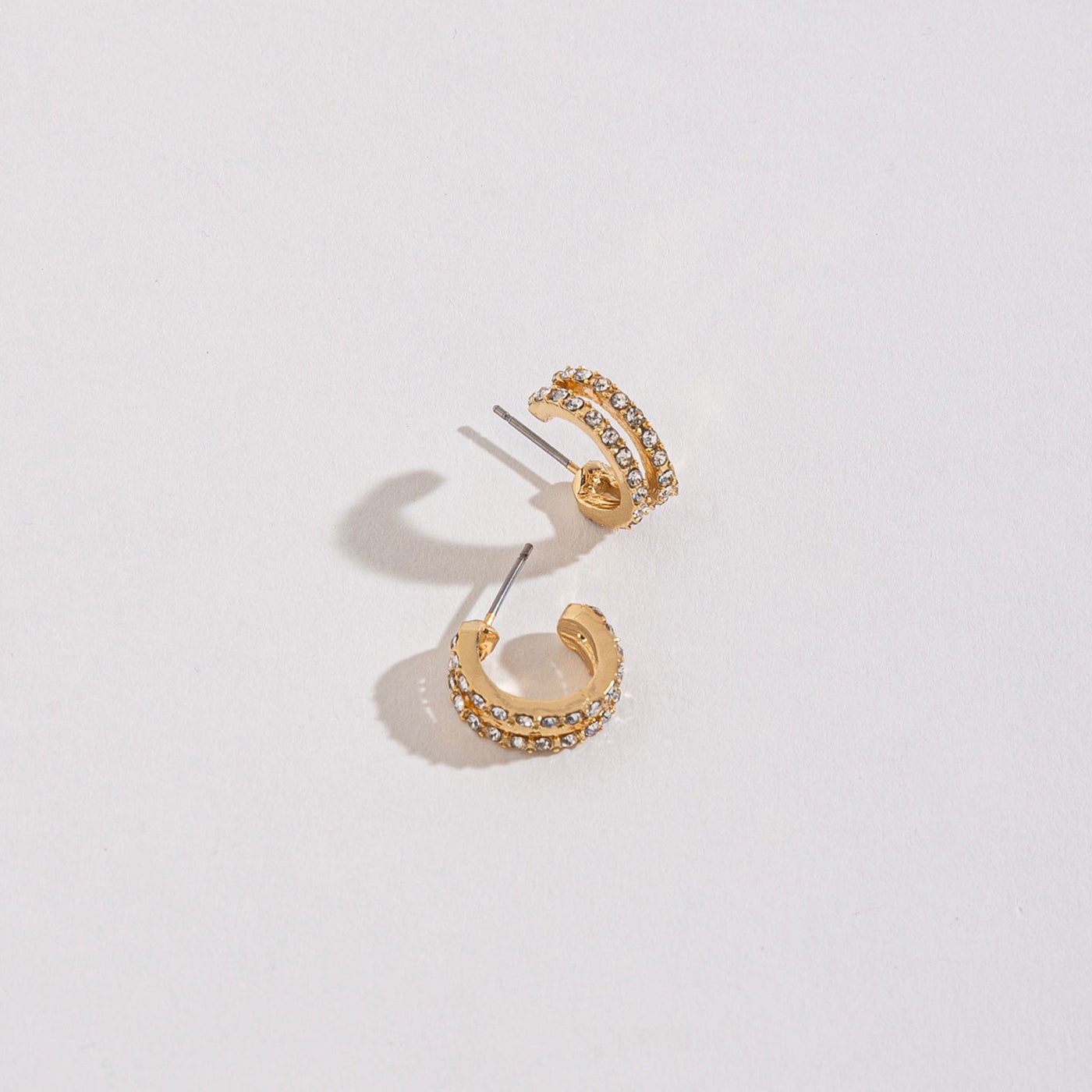 gold double pave huggie hoops on a white background.