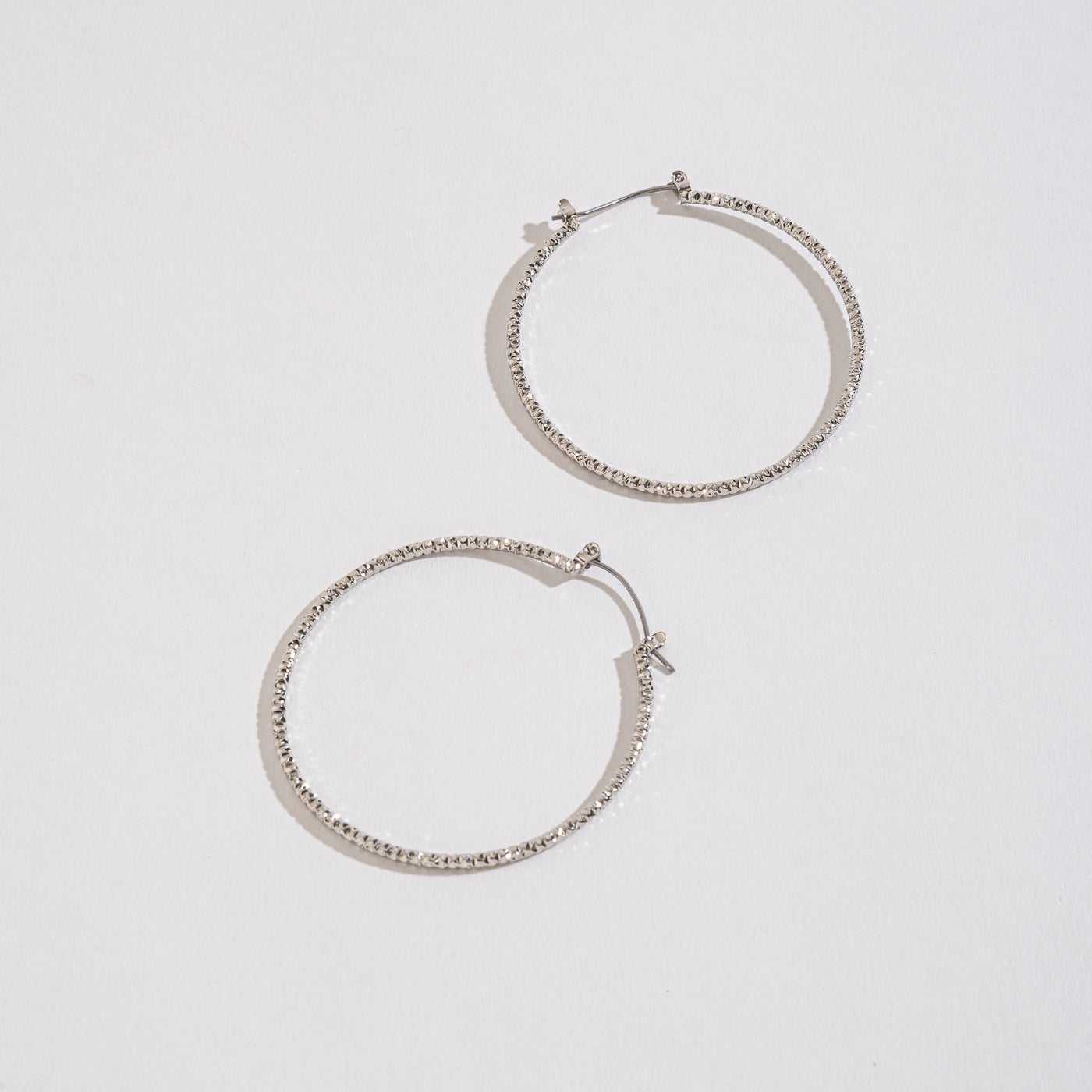 silver textured hoops on a white background.