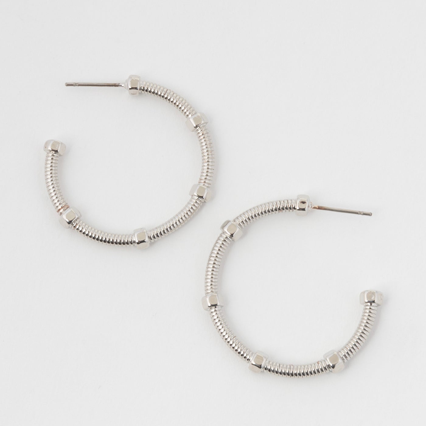 silver dotted hoops on a white background.