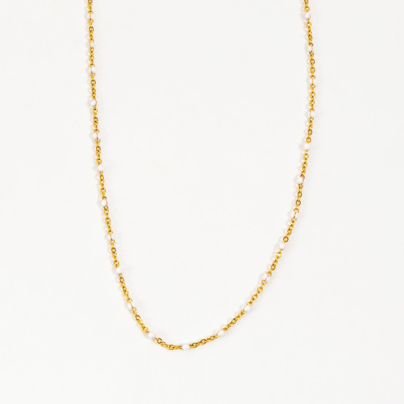 gold chain with small white beads.