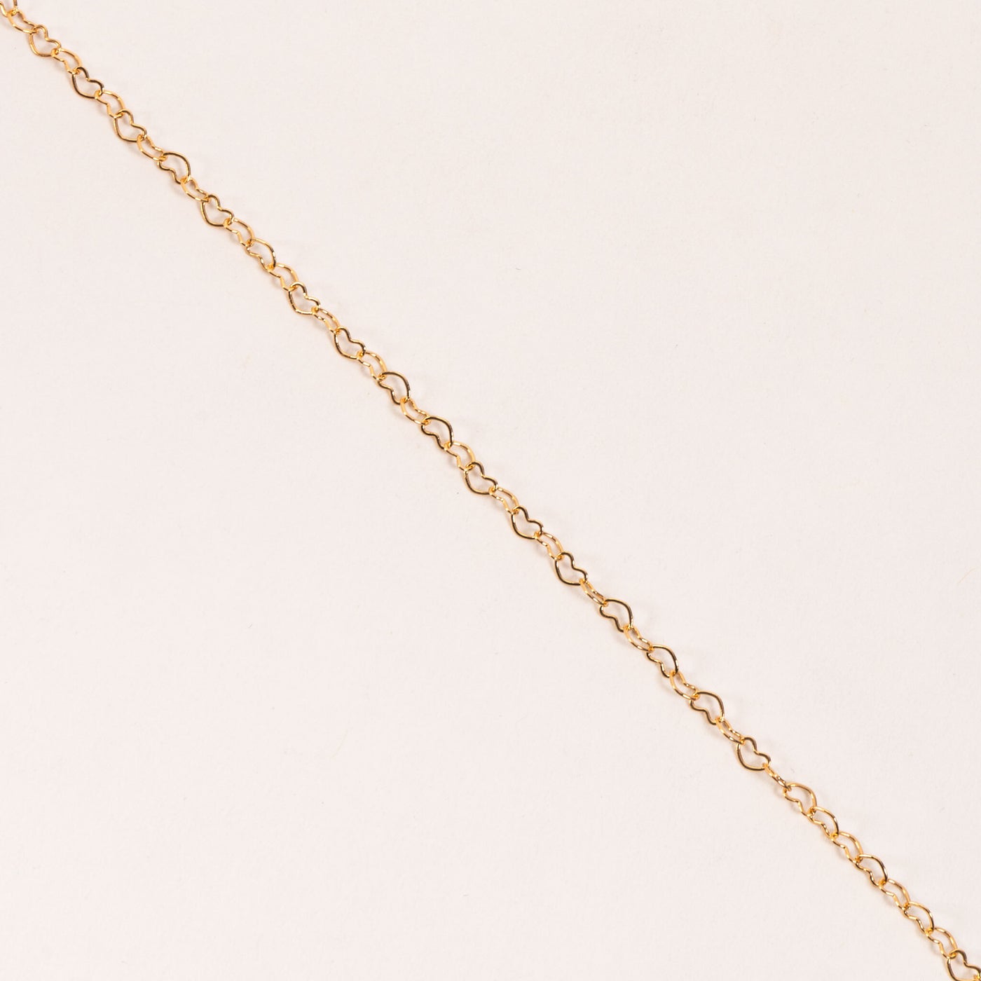 close-up if gold heart chain necklace.