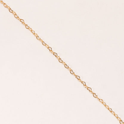 close-up if gold heart chain necklace.