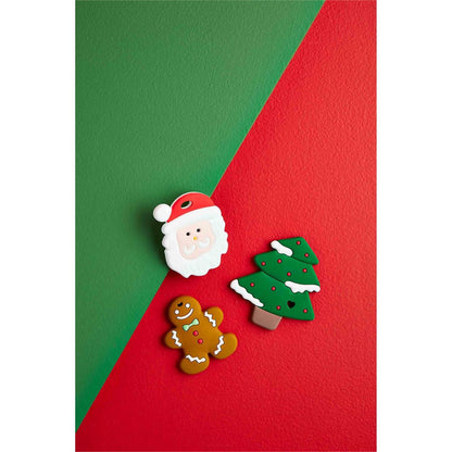 Three styles of Christmas teethers arranged on a red and green background.