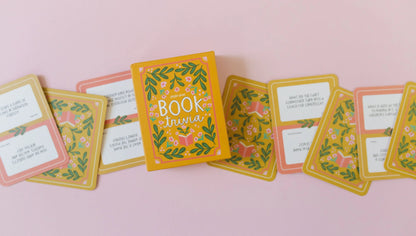 box of Book Trivia Card Set arranged with several card on a pale pink background