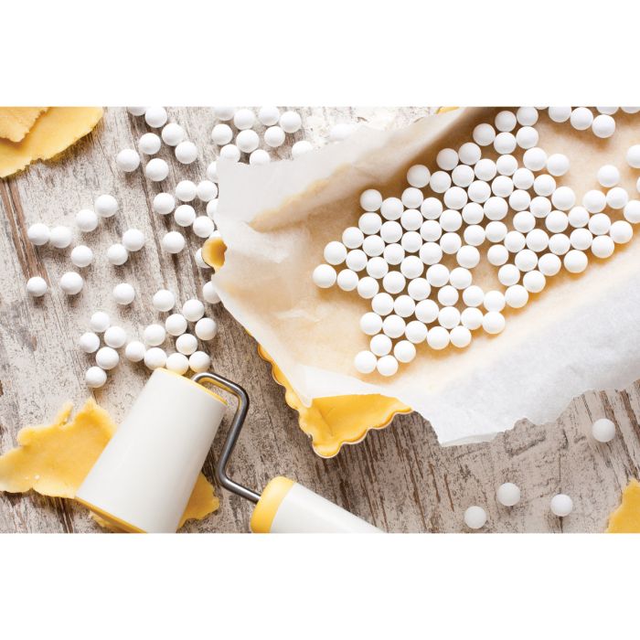 pie weights in a tart pan filled with unbaked crust