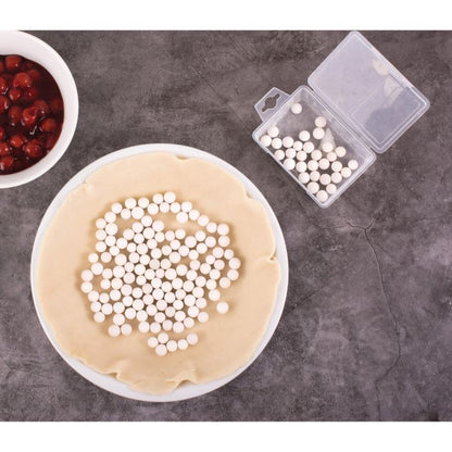 pie weights in an unbaked pie crust in a white pie pan