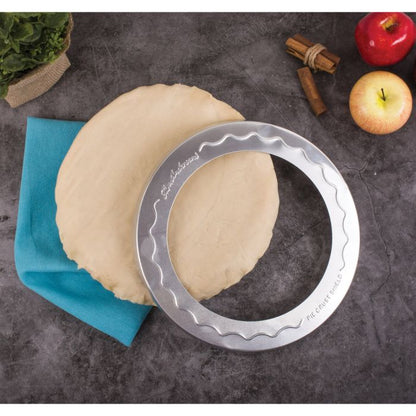 Pie Crust Shield laying on a a counter with rolled out pie crust dough