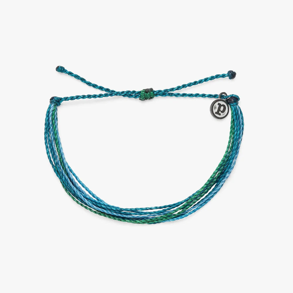 Pura Vida multi strand corded bracelet in varying shades of teal and green with a Pura Vida logo charm