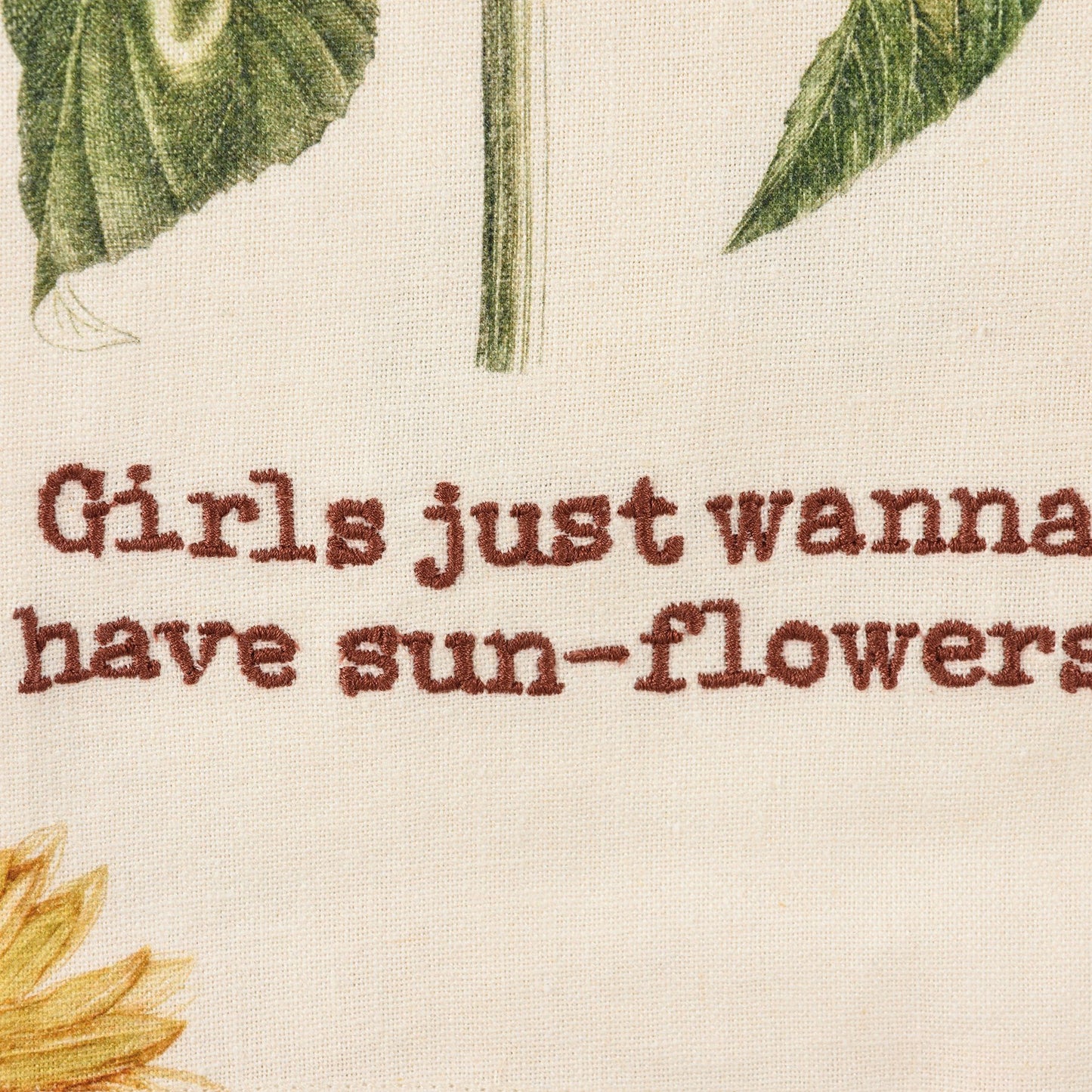 Close up of "Girls just wanna have sunflowers" embroidery on towel