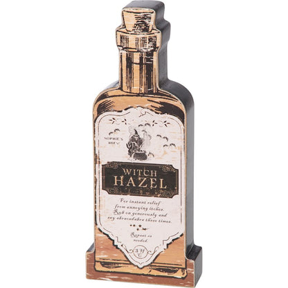 Decorative bottle-shaped wooden cut-out with 'Witch Hazel' label on a white background
