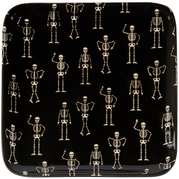 A square black plate with rounded corners, featuring a repeating pattern of small skeleton figures in various poses.
