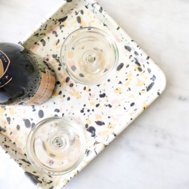 top view of pink sunset tray with bottle of wine and glasses on it.