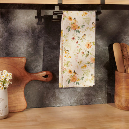 Floral towel hanging on a kitchen rack next to wooden cutting board, vase, and utensils.